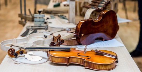 skrzypce i części do skrzypiec leżące na stole