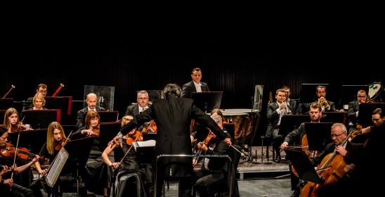 dyrygent stojący przed orkiestrą