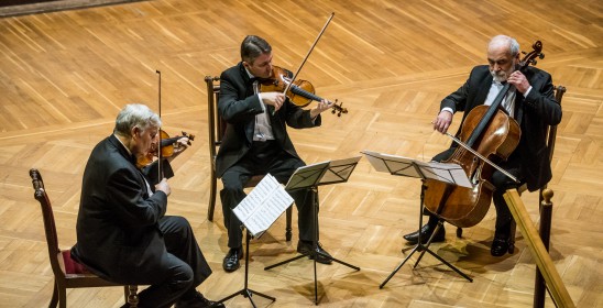 trzech mężczyzn gra na instrumentach