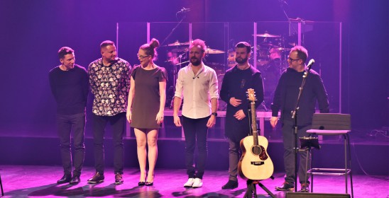 kobieta i pięciu mężczyzn stojących na scenie
