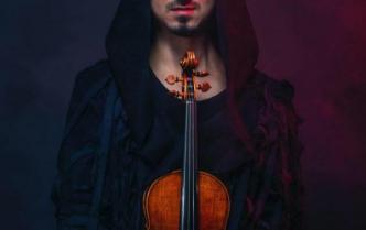 mężczyzna z krótką brudką w ciemnym stroju przed sobą trzyma skrzypce