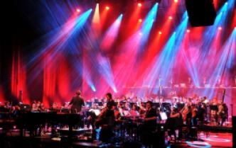 w czerwono-niebieskim oświetleniu na scenie orkiestra symfoniczna