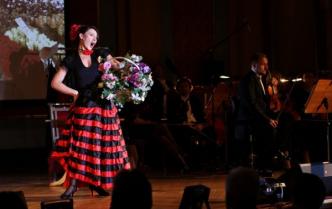 śpiewająca kobieta w hiszpańskiej sukni z kwiatami w ręku