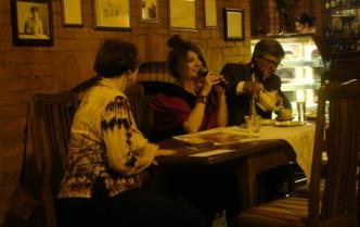 trzy osoby siedzące przy stole w kawiarni