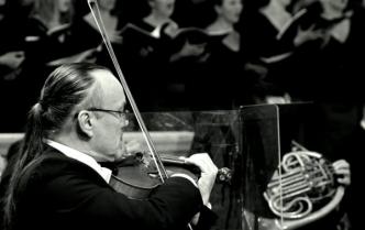 czarno-biała fotografia mężczyzny z kitką grającego na skrzypcach