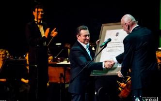 Dyrektor Toruńskiej Orkiestry Symfonicznej otrzymuje od prezydenta miasta oprawiony dokument
