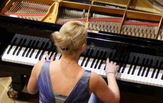 kobieta w sukni gra na fortepianie
