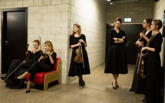 na korytarzu przed wejściem na salę koncertową w czarnych strojach ze skrzypcami w dłoniach czeka szejść kobiet czeka 