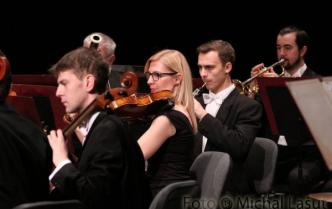 trzech mężczyzn i kobieta grający na instrumentach