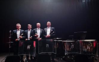 czterej mężczyźni perkusiści stoją trzymając pałeczki w rękach