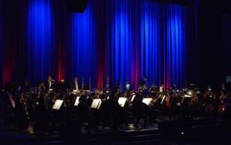 orkiestra na scenie, tło podświetlone na niebiesko