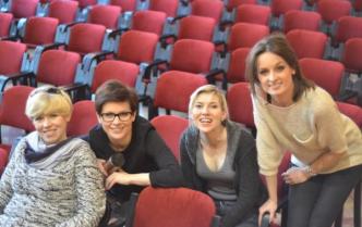 cztery kobiety siedzą w fotelach na widowni
