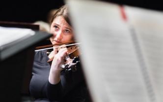 kobieta ze skupioną twarzą gra na skrzypcach