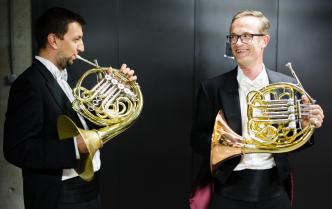 muzycy grający na waltorni na zasceniu