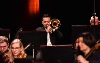 muzyk grający na puzonie na scenie Sali Koncertowej