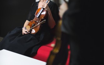 siedząca kobieta trzymająca skrzypce