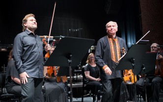 dwóch mężczyzn trzymających skrzypce