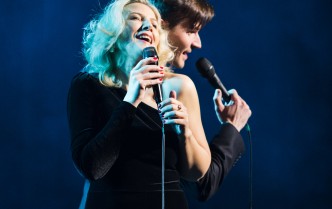 kobieta i mężczyzna śpiewający do mikrofonów
