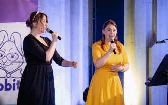 dwie kobiety śpiewające do mikrofonów