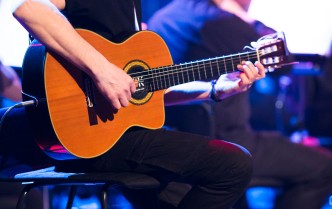 mężczyzna grający na gitarze akustycznej