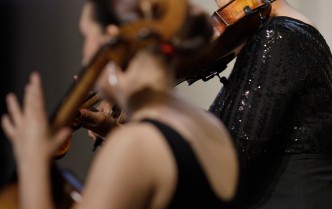 zbliżenie na dwie kobiety w czarnych strojach grające na wiolonczeli i altówce
