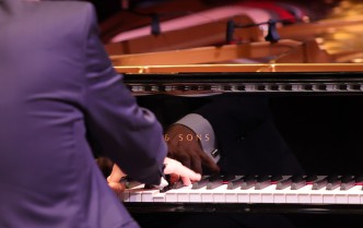 zbliżenie na dłonie mężczyzny grającego na fortepianie