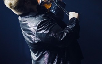 mężczyzna ukazany w cieniu grający na skrzypcach