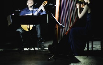 mężczyzna grający na gitarze i kobieta grająca na harfie