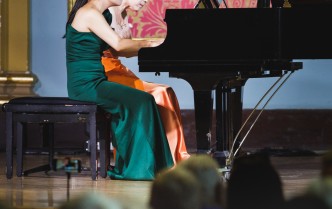 dwie kobiety grające na fortepianie