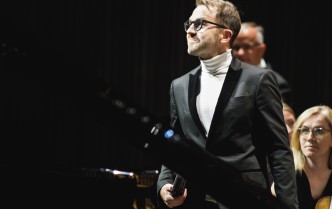 mężczyzna stojący przy fortepianie