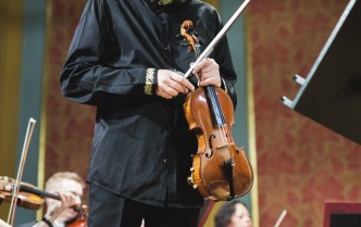 stojący mężczyzna trzymający skrzypce