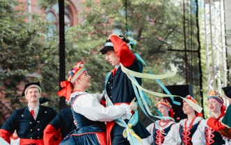 kobieta i mężczyzna w stroju kujawskim tańczą, mężczyzna przytrzymuje jedną ręką kapelusz