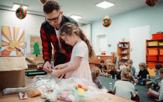 prowadzący wraz z dziewczynką wybierają materiały do tworzenia instrumentów