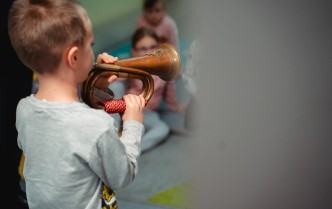 chłopiec grający na instrumencie dętym