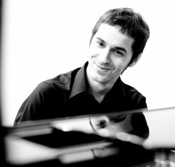 Uśmiechnięty mężczyzna siedzący przed fortepianem - zdjęcie czarno-białe