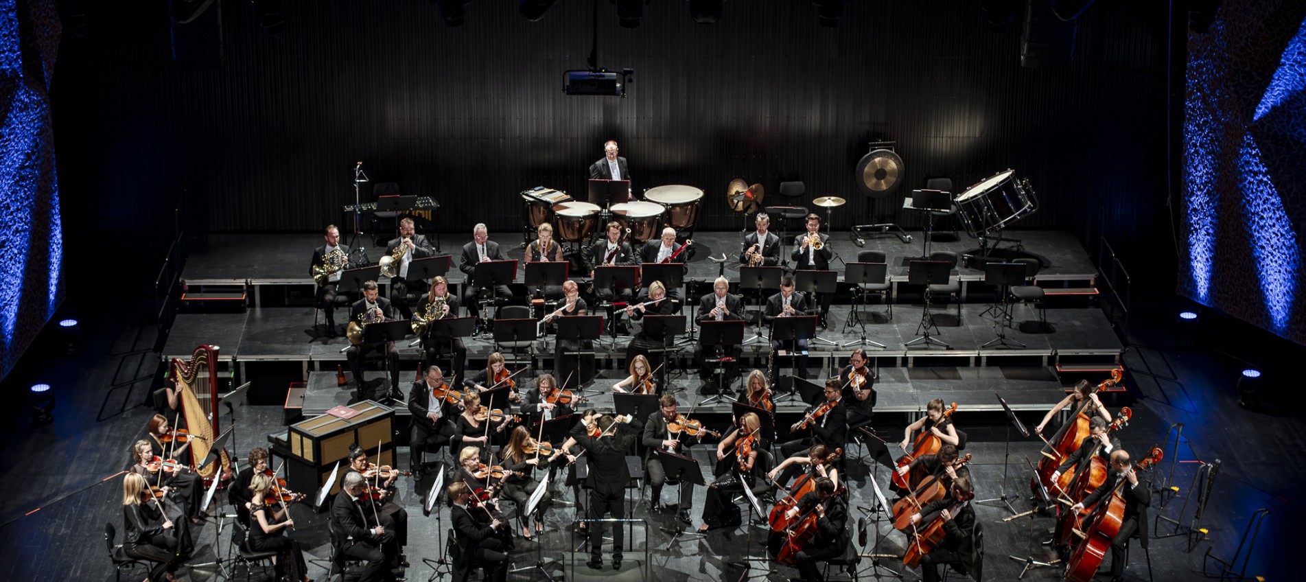 orkiestra na scenie widziana z konca sali