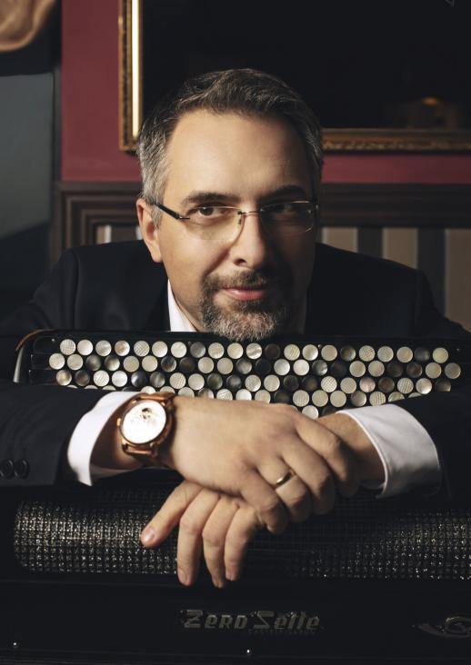 portrait of a man leaning against an accordion