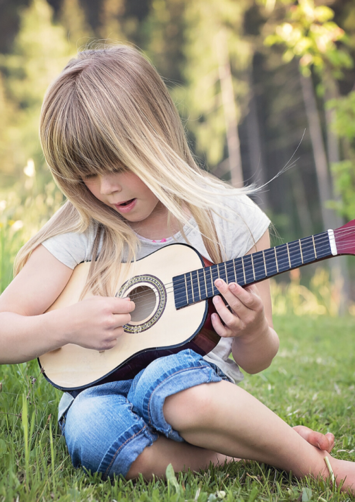 girl playing guitar and concert title