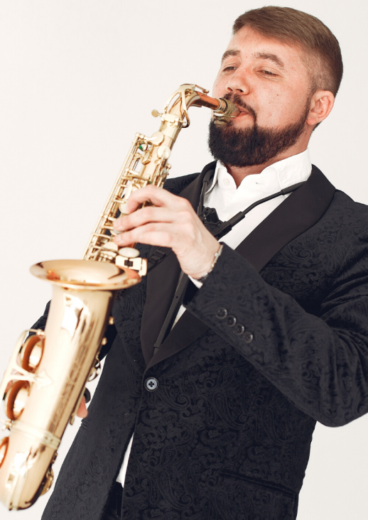 man playing the saxophone and the title of the concert
