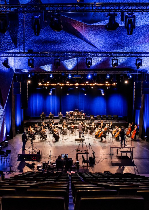 orkiestra na scenie w tle niebieskie światła