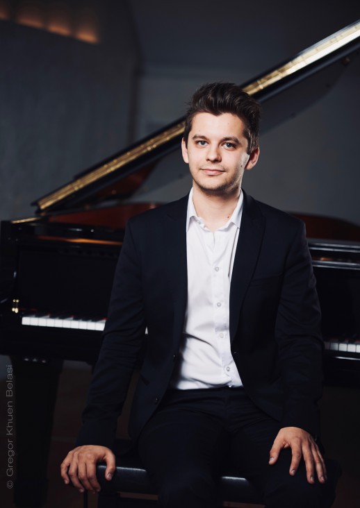 The man sitting with his back to the piano