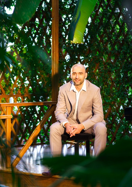 siedzący za drzewami mężczyzna