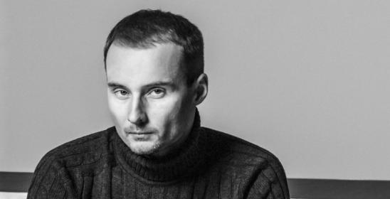 młody siedzący mężczyzna z rękami opartymi na kolanach