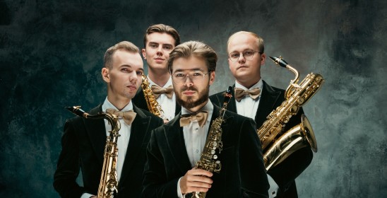czterech mężczyzn trzymających saksofony