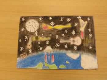 Praca plastyczna dziecka przedstawiająca planetę ziemię oraz kosmos z gwiazdami i instrumentami