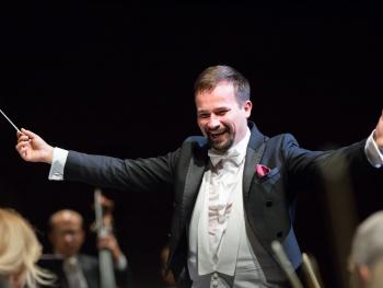 smiling man, conductor with outstretched hands